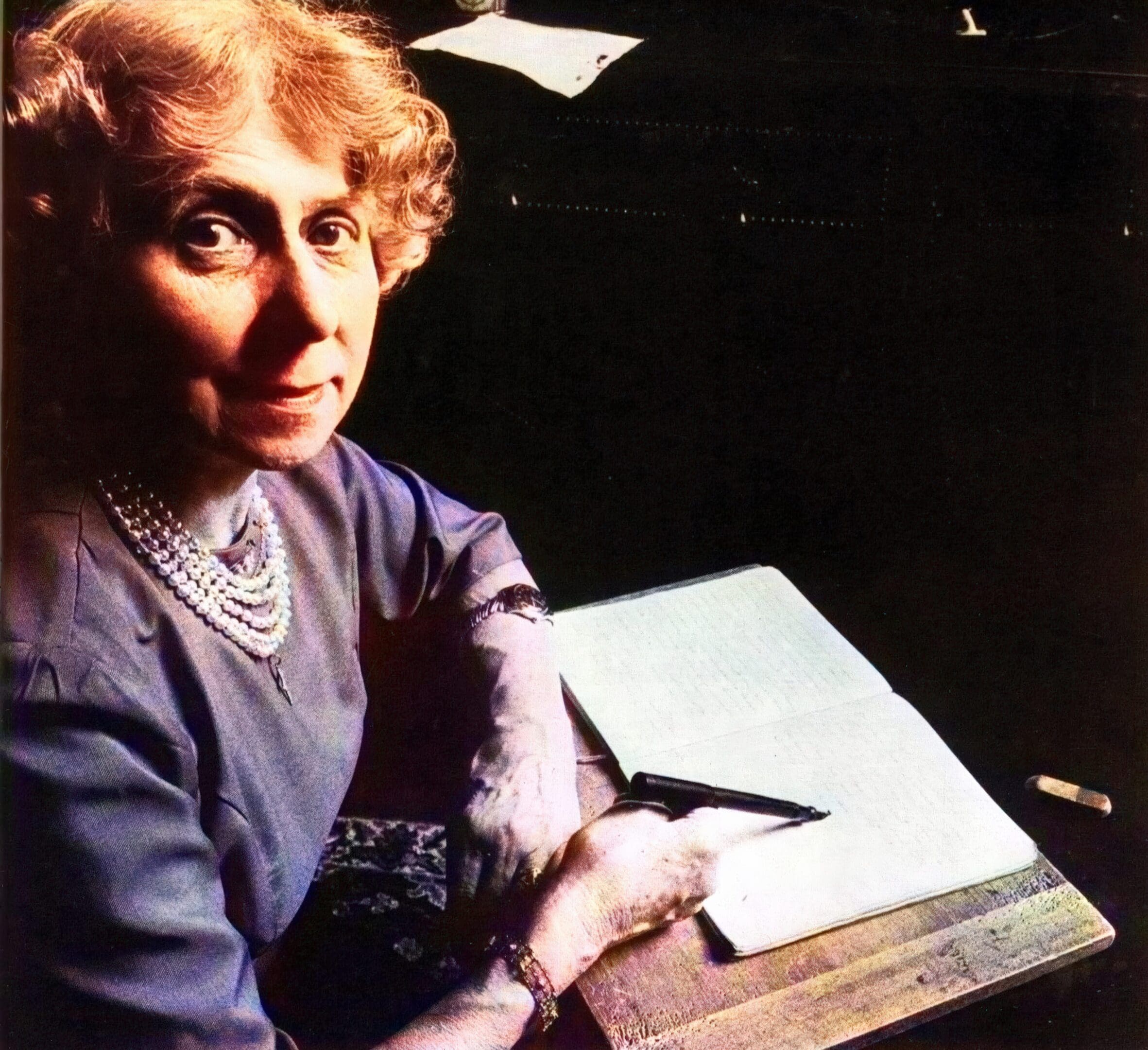 Grace Rosher ready for writing. Each of the spirits that communicates through her apparently uses the lightly propped pen to produce its own distinctive style of handwriting.