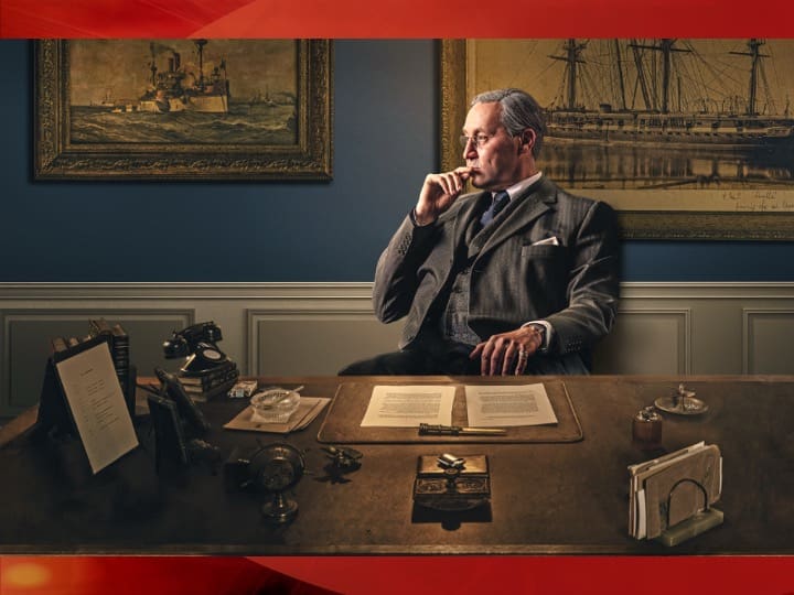 Man in a suit sitting at desk.