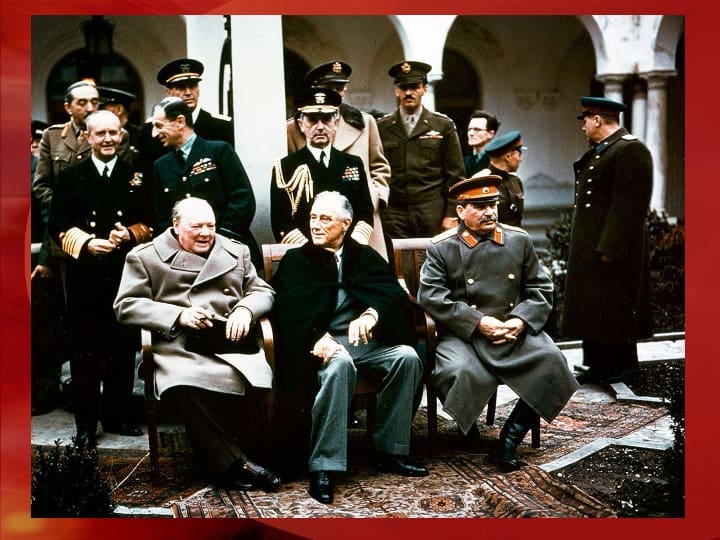 World leaders sitting together, military officials standing.