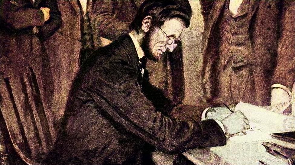 Man writing at desk with onlookers.