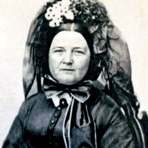 Victorian-era woman with elaborate floral headdress.